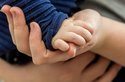 Erwachsene Hand hält die eines Babys Erwachsene Hand hält die eines Babys