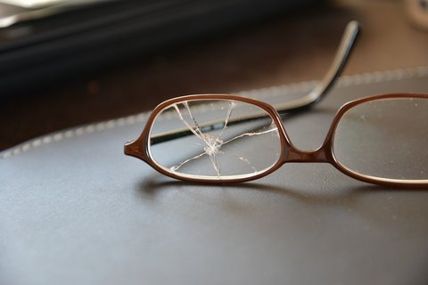 Brille mit einem zerbrochenen Glas
