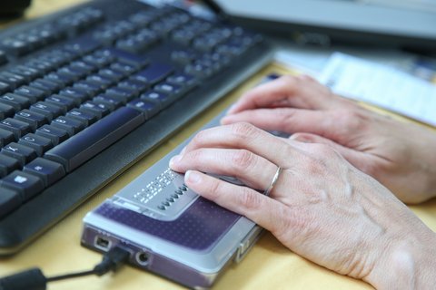 Beide Hände benutzen vor PC-Tastatur Braillezeile Beide Hände benutzen vor PC-Tastatur Braillezeile