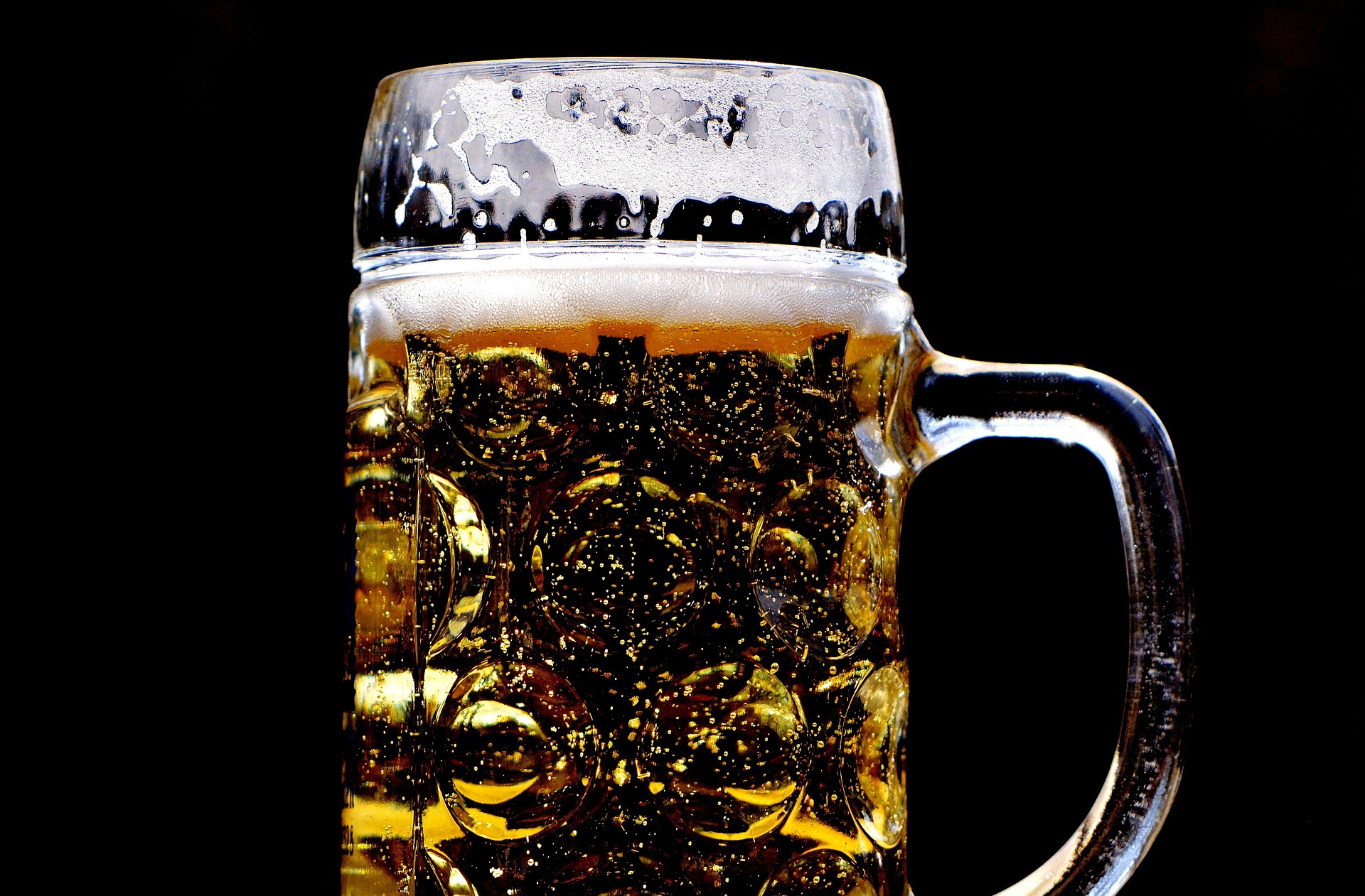 Voller Bierkrug vor schwarzem Hintergrund